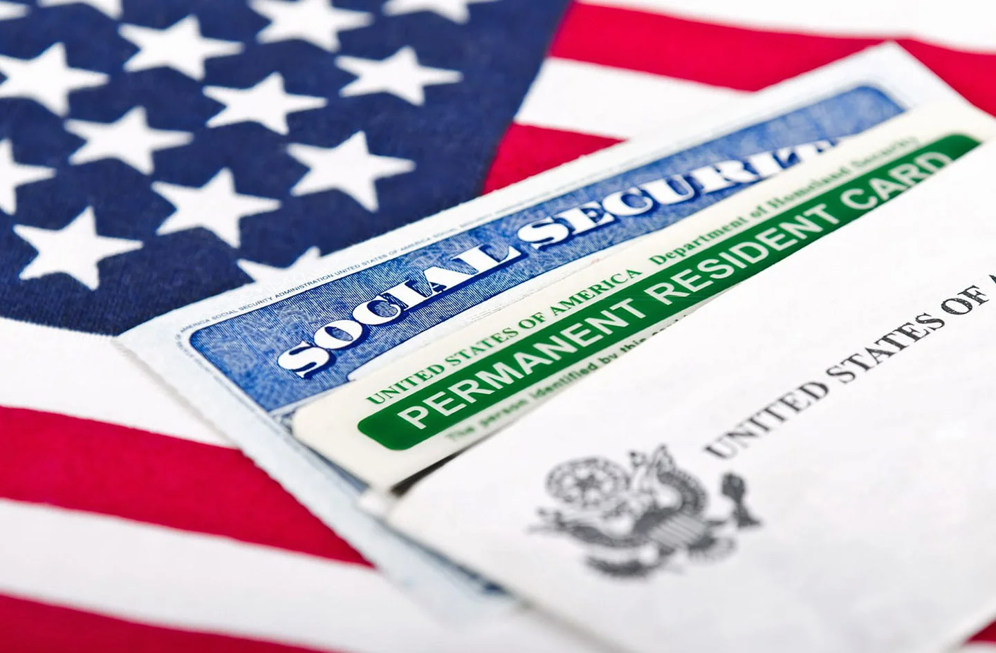 Composite image of American flag and Social Security and Permanent Residence cards.