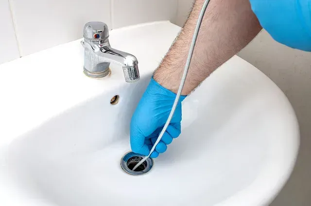 Plumber cleaning drain