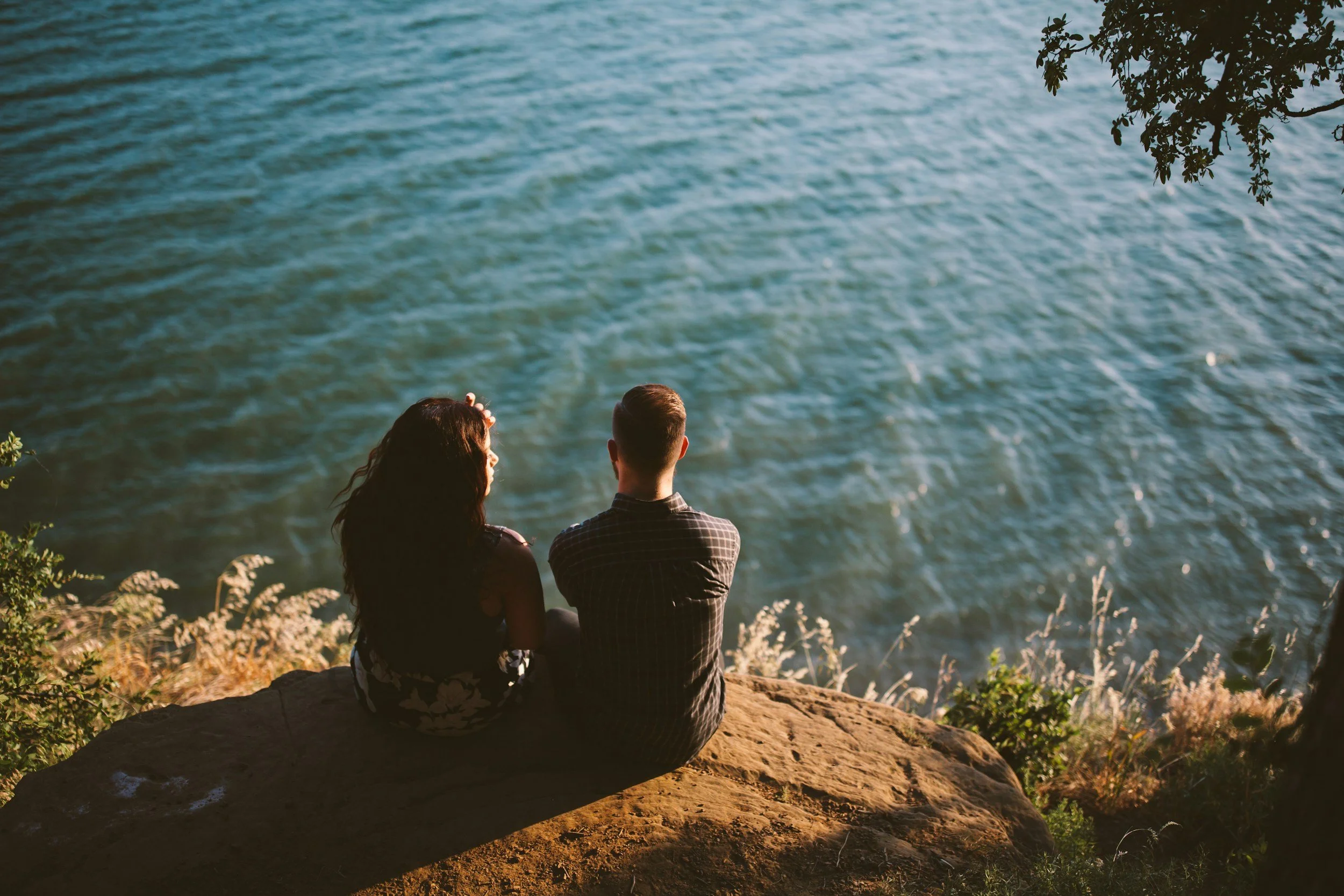 Couple by water at sunset