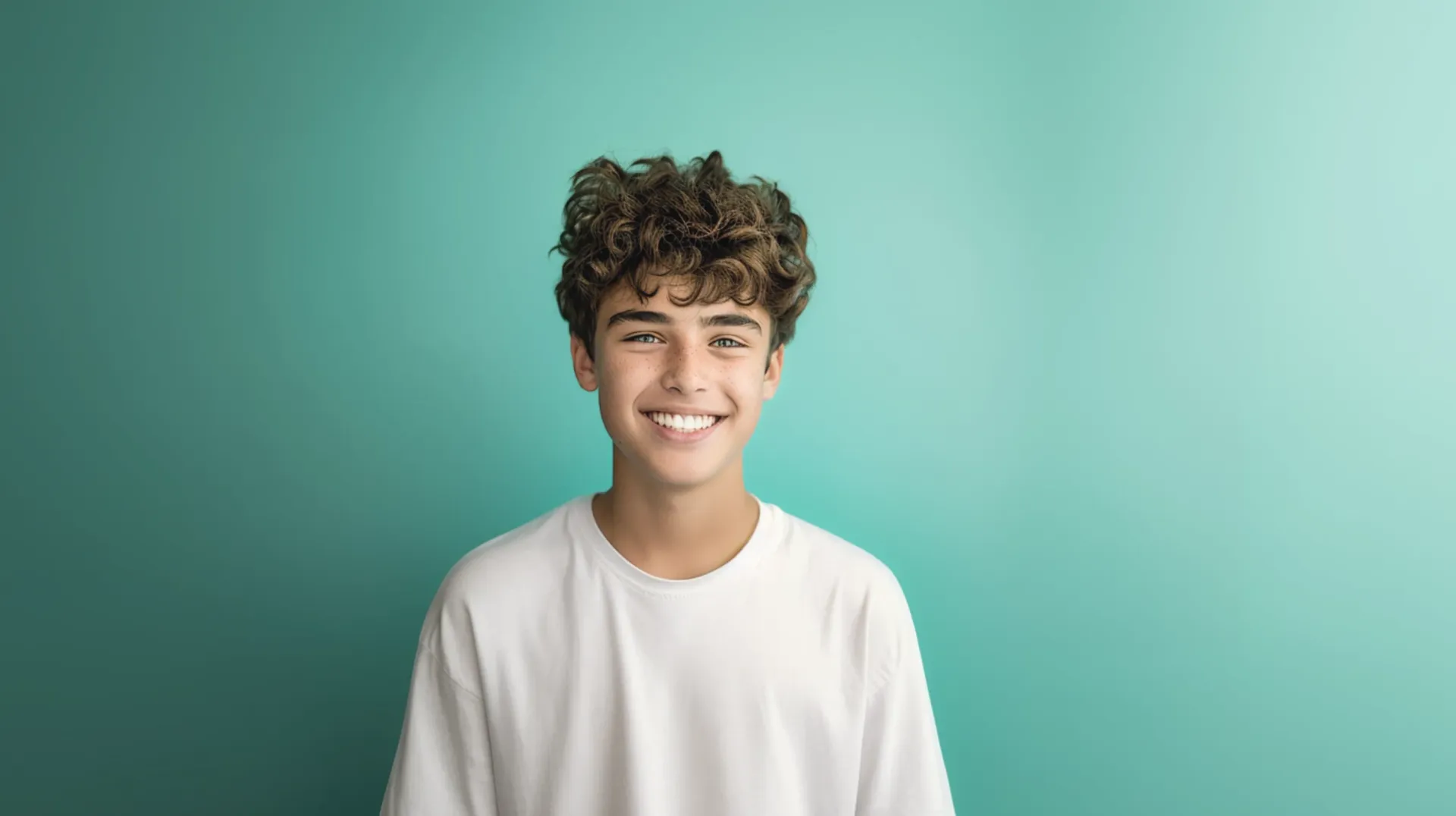 A young man with curly hair smiling