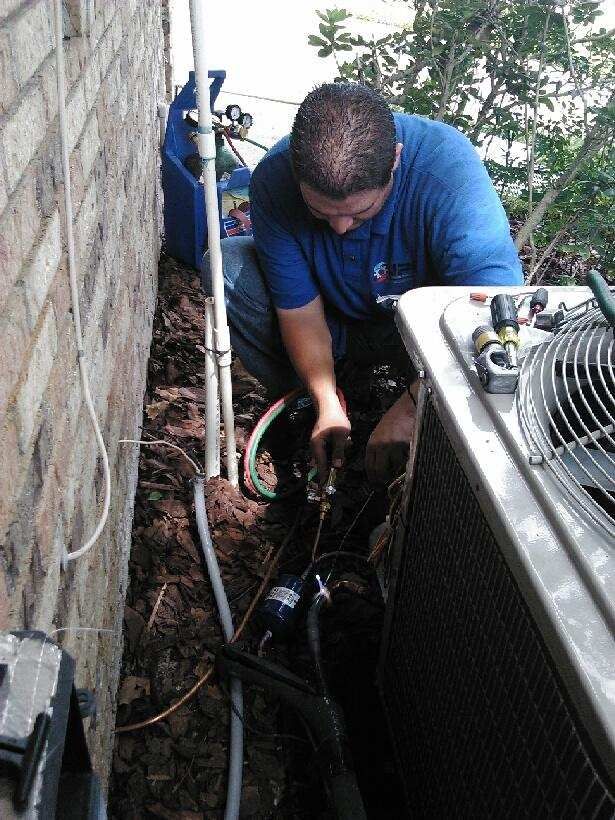 HVAC technician working on unit