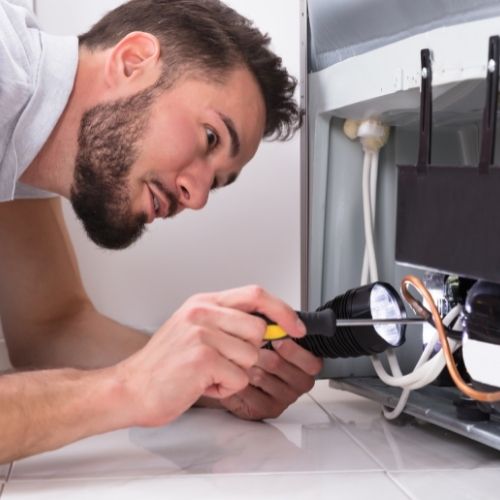Technician repairing refrigerator Louisville KY