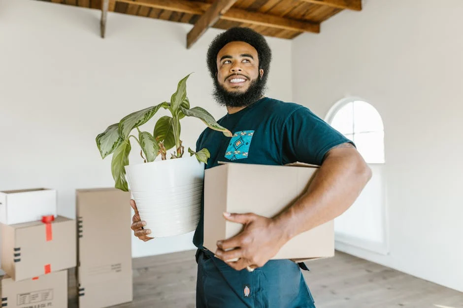 Smiling man holding moving box in new home