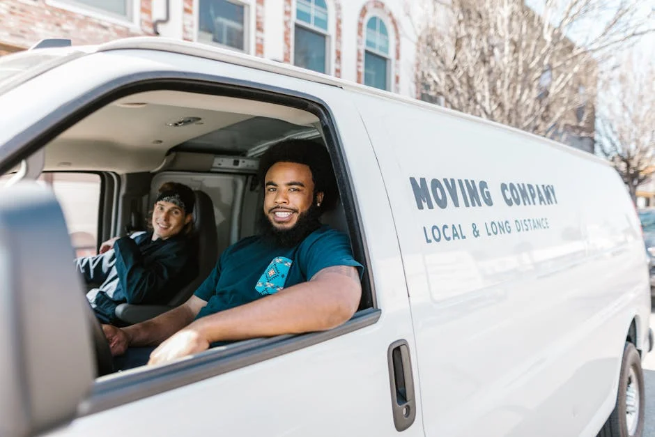 Two movers smiling from moving van