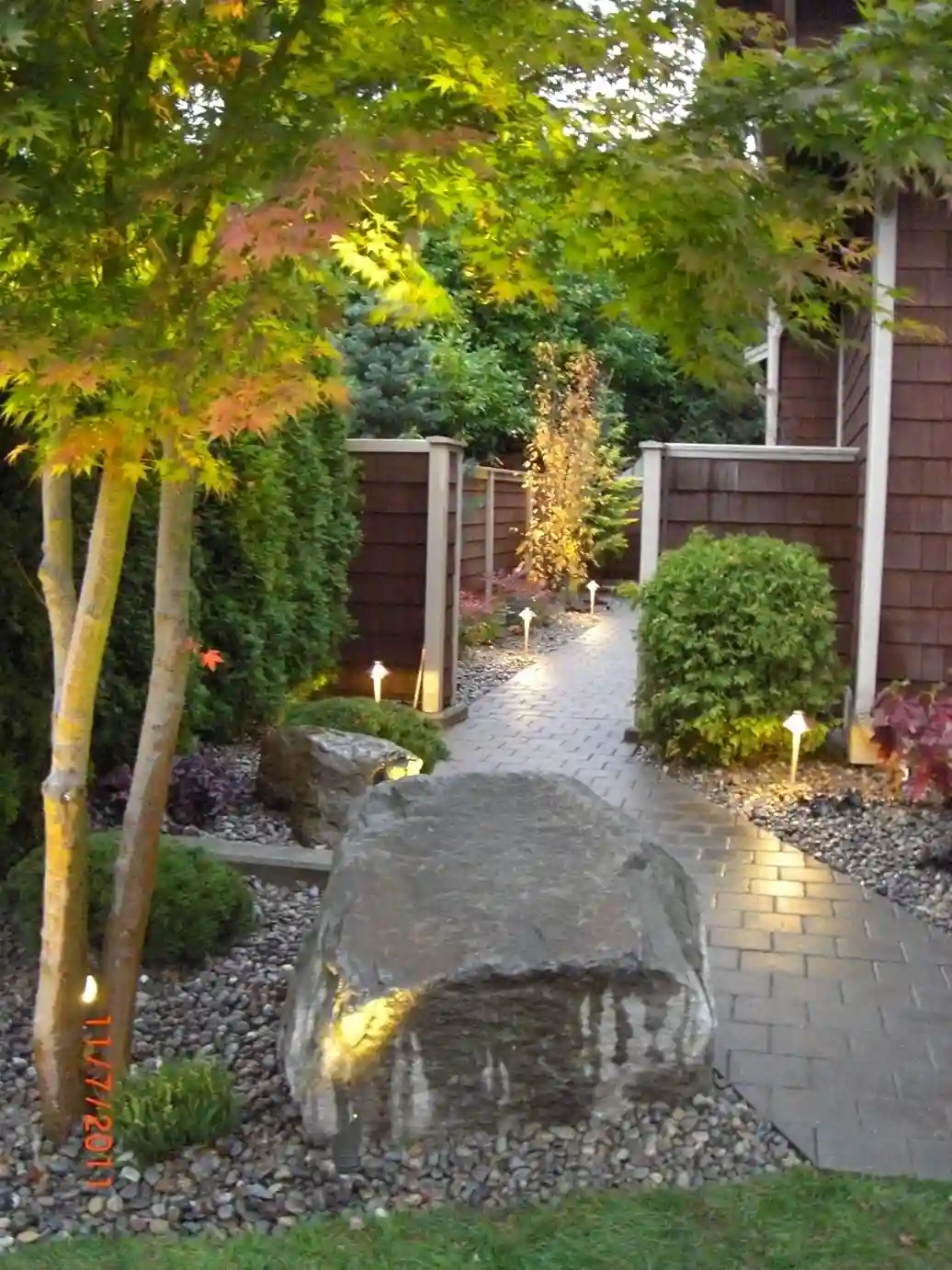 Landscaped garden path at dusk with water feature