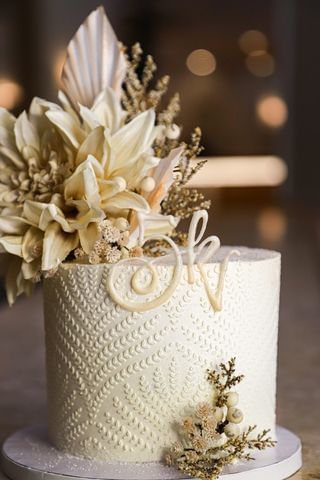 Elegant white cake with intricate designs at New River Cafe Bakery