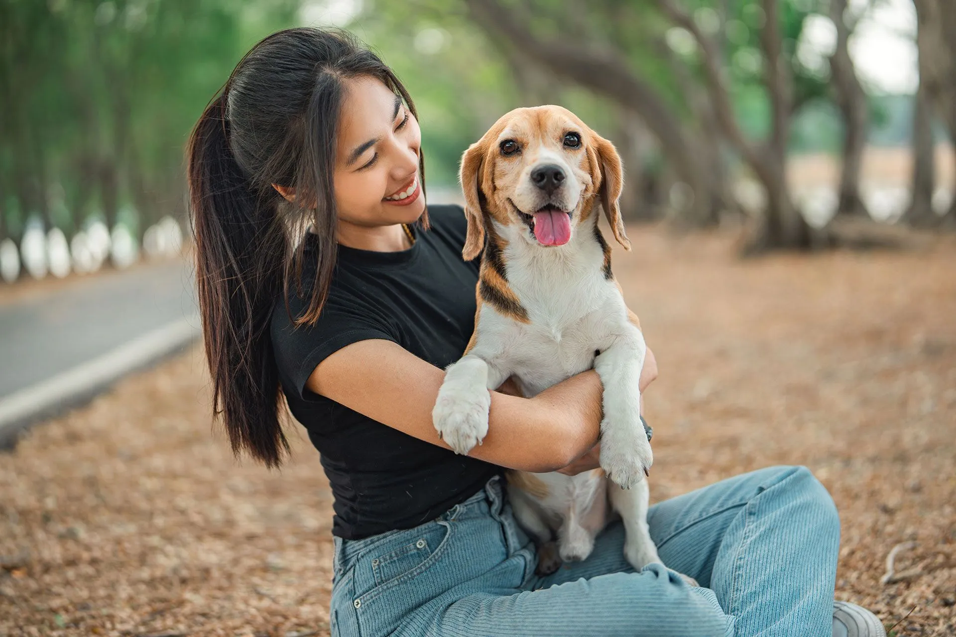 Happy woman playing with dog outdoors — pet relocation