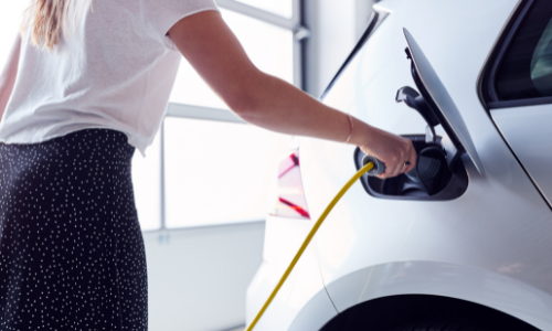 woman using EV charging station in garage
