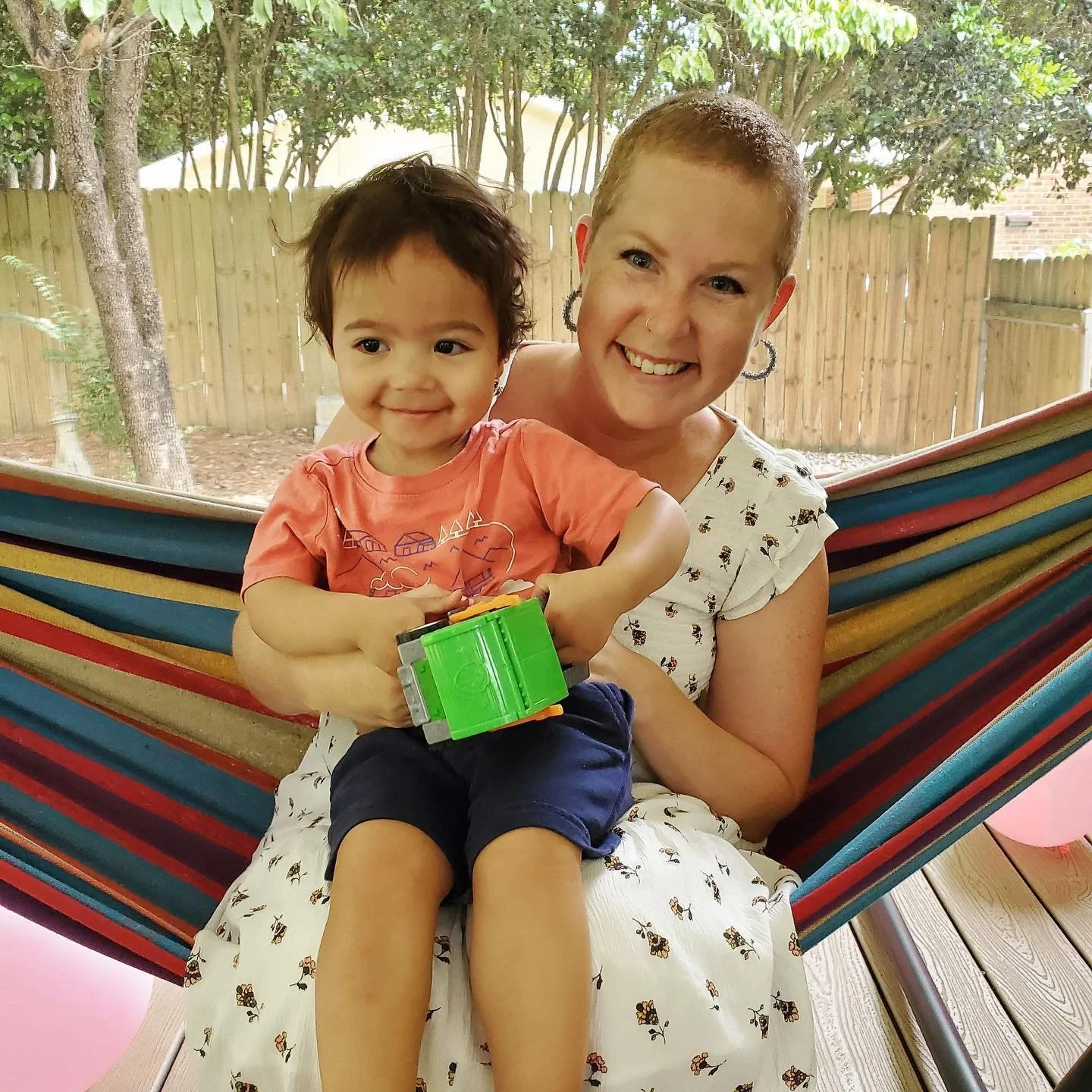 Smiling woman and child on a colorful hammock