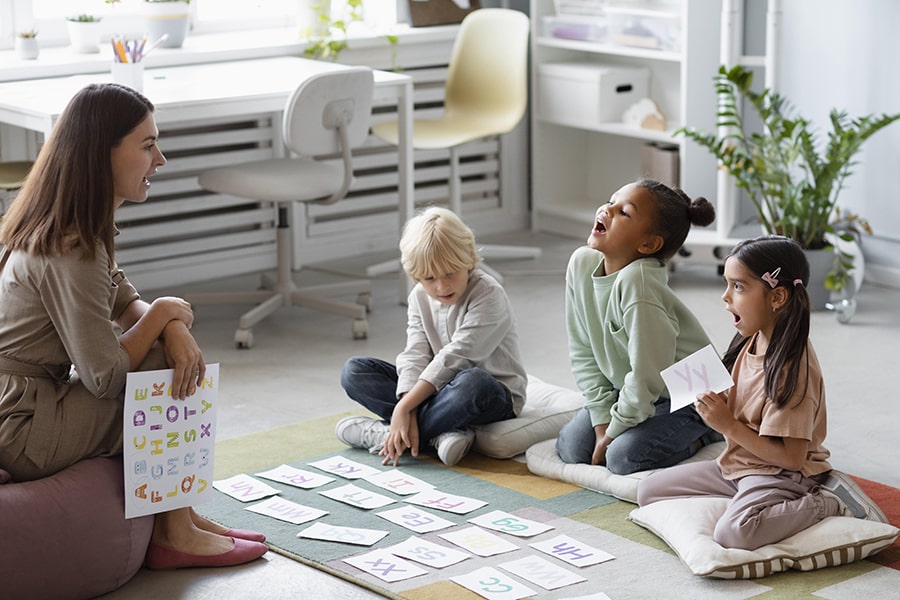Young woman doing speech therapy with children