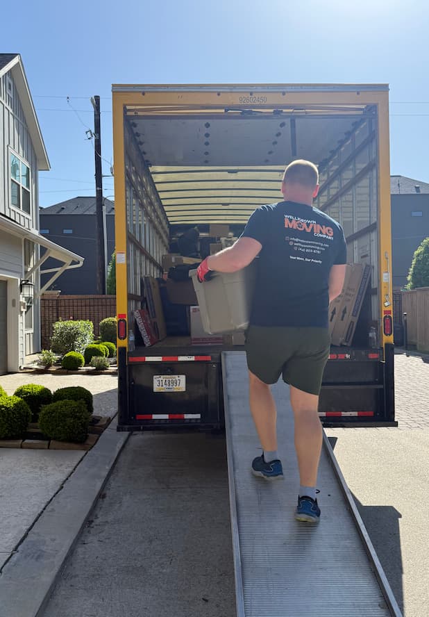 Team wrapping a large sofa with protective blankets