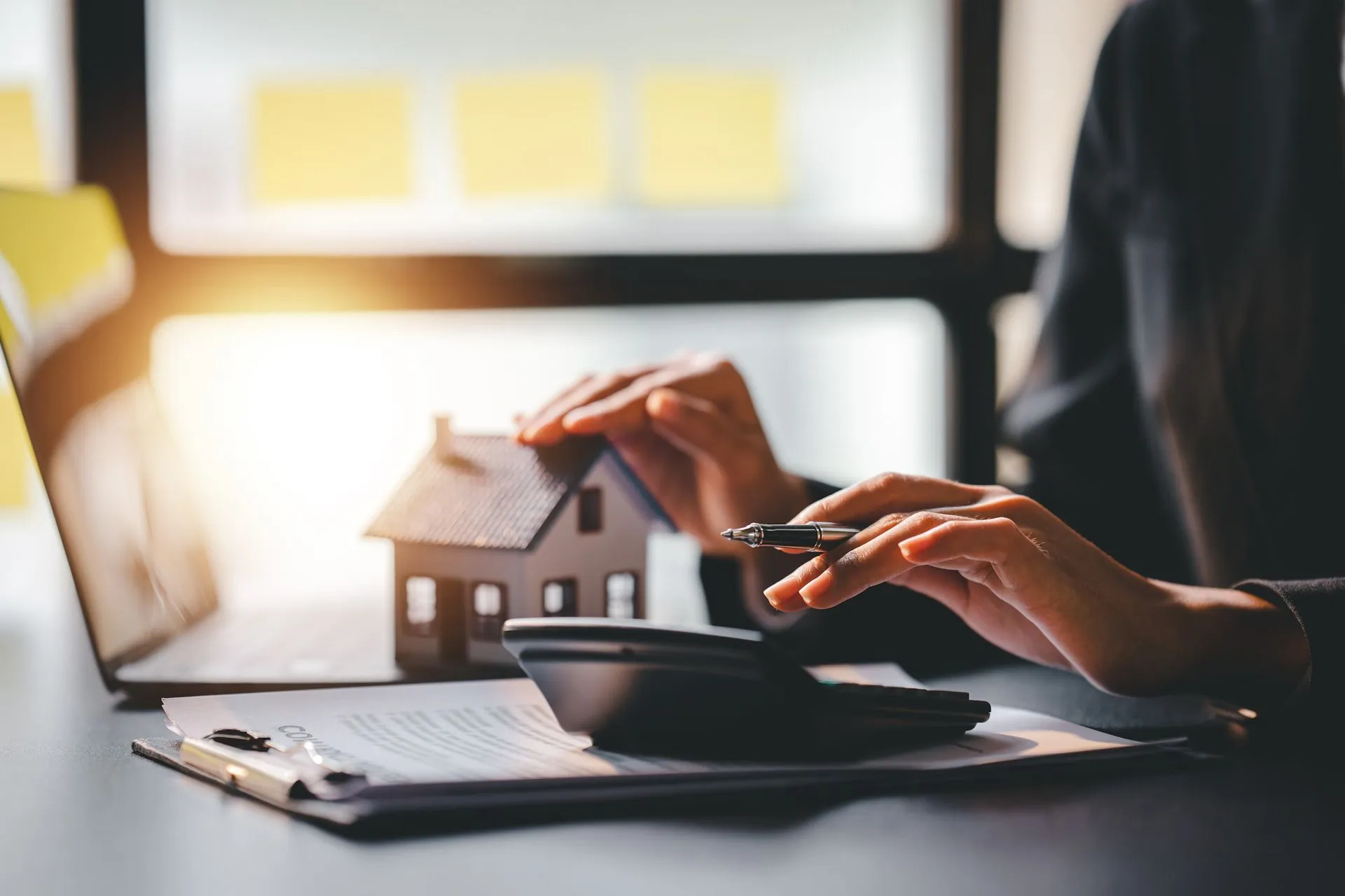 Mortgage advisor working with calculator and laptop